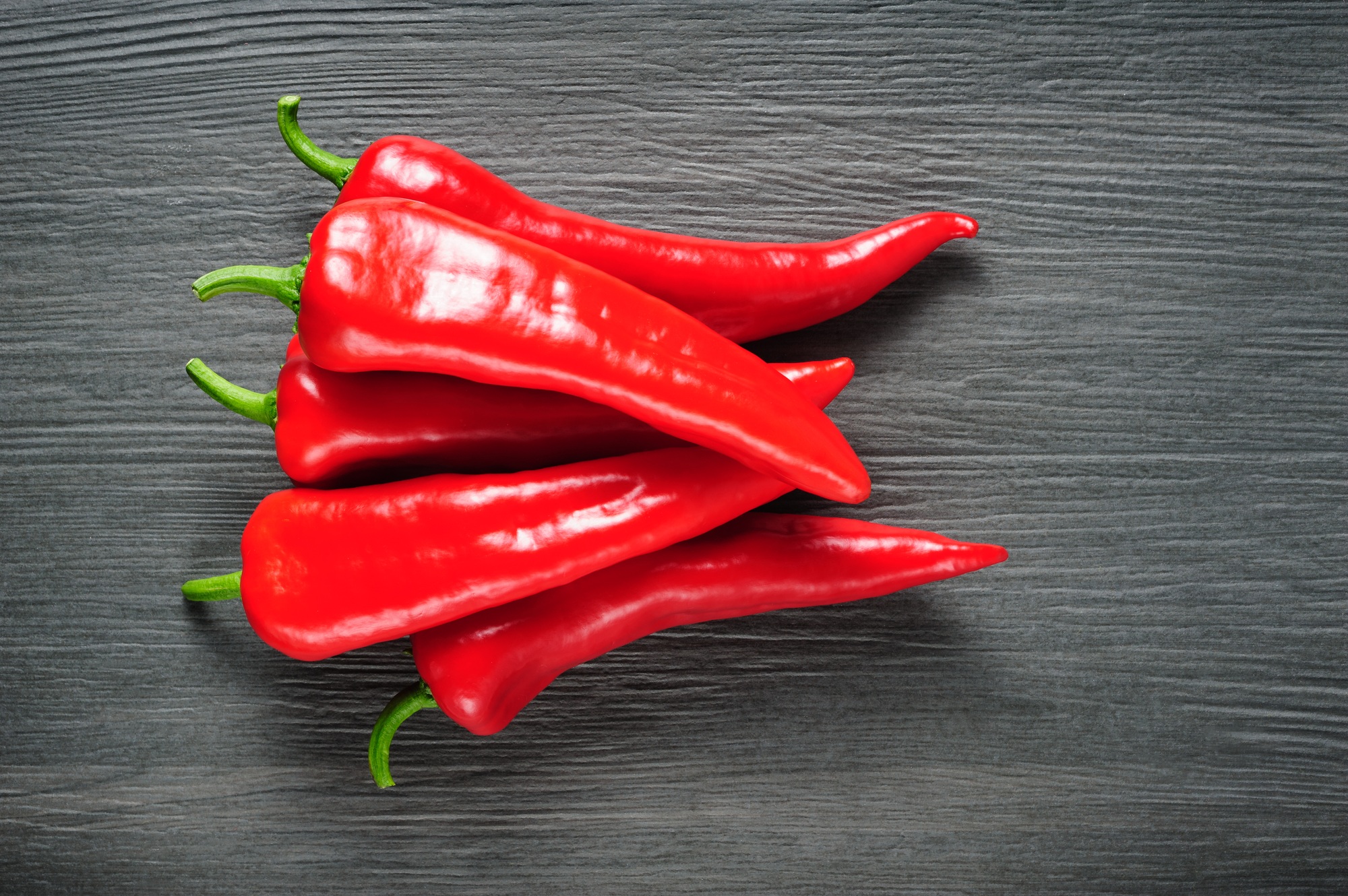 Sweet red Kapia peppers on a dark shale stone background